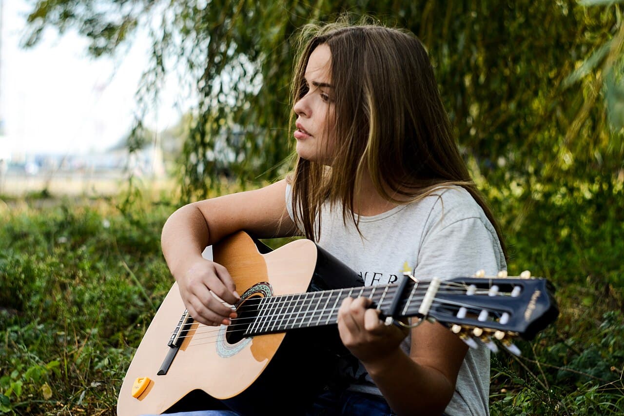 Musician playing an acoustic guitar outdoors