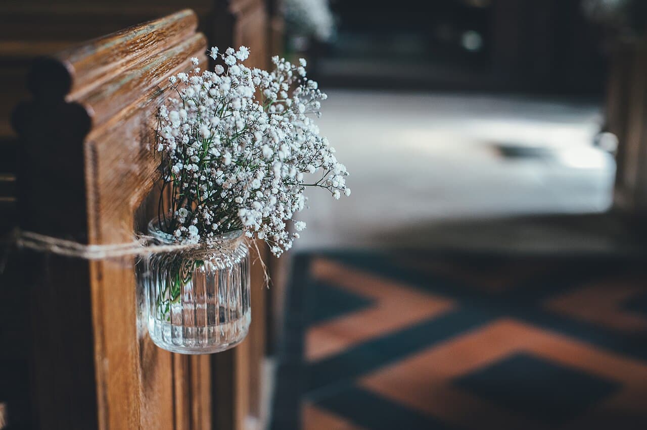 Flower arrangements decorating the pews of a church