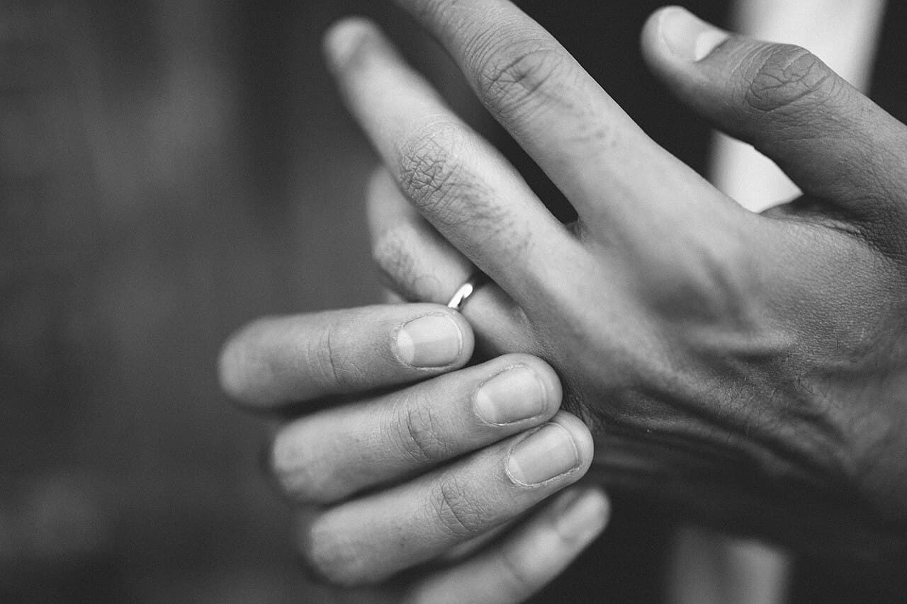 Hands with a wedding band, black and white
