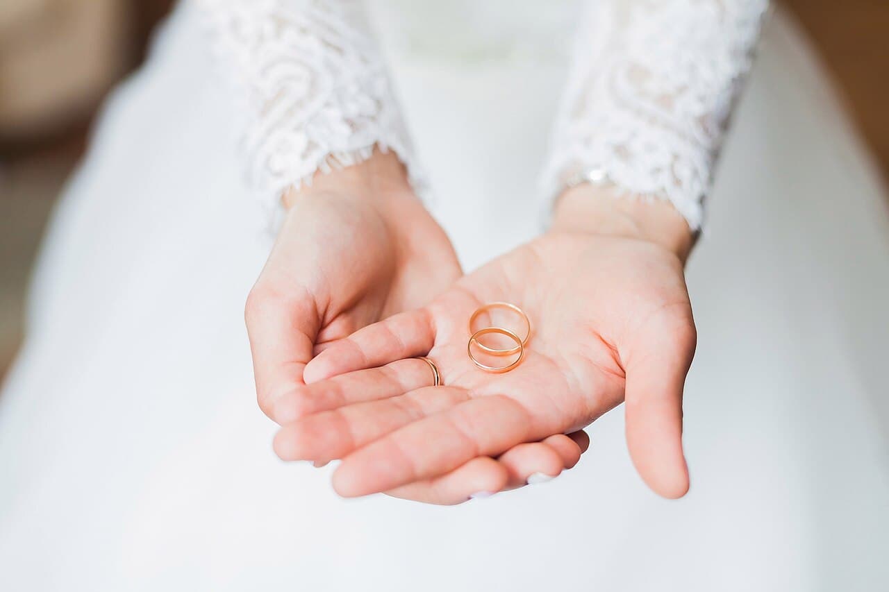 Hands holding wedding bands