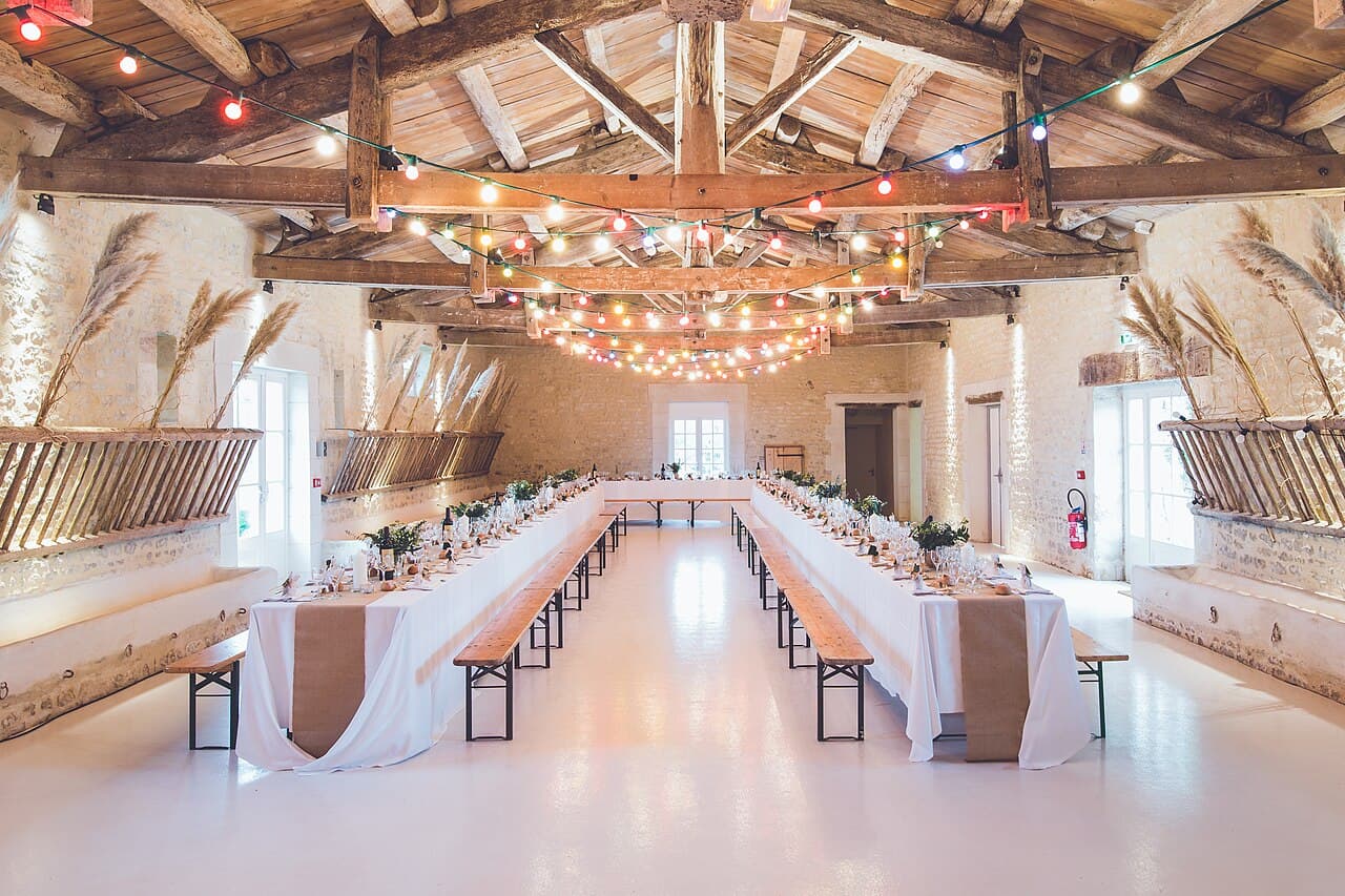 Long wedding reception tables in a rustic hall