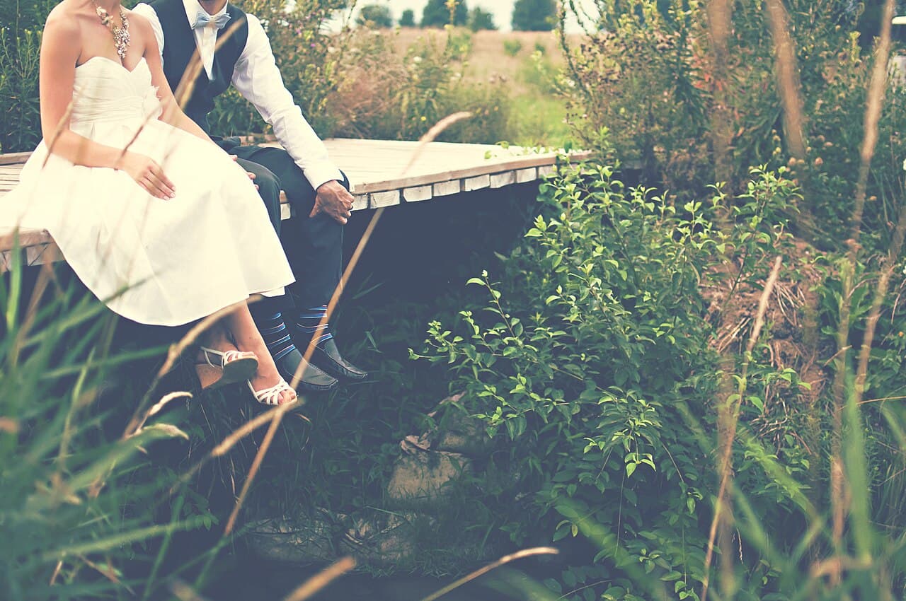 Couple on a footbridge in a green outdoor setting
