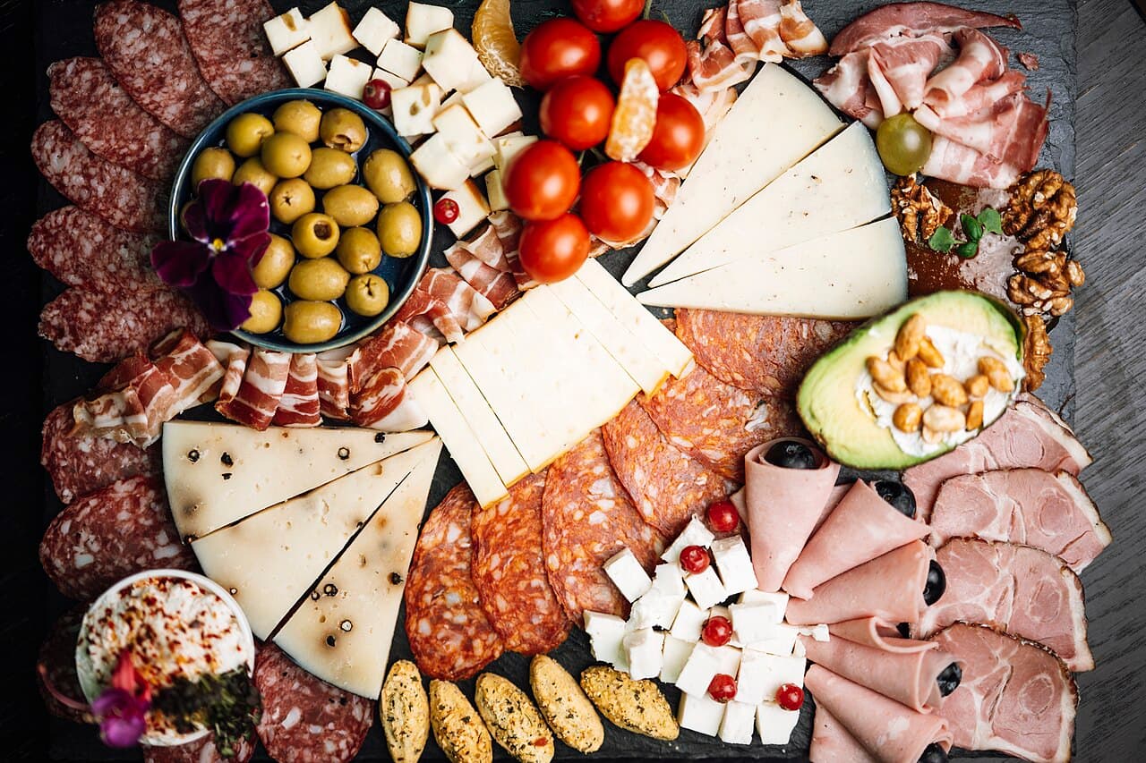 Board of cheeses, meats, olives and vegetables